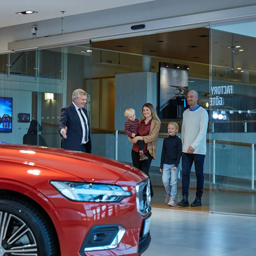 salesperson showing a car to a family
